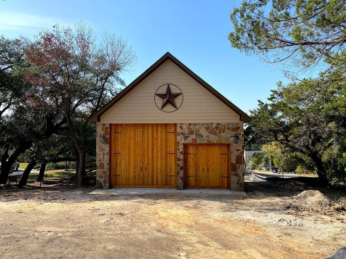 Detached garage with cedar doors, stone corners and a star on the front gable