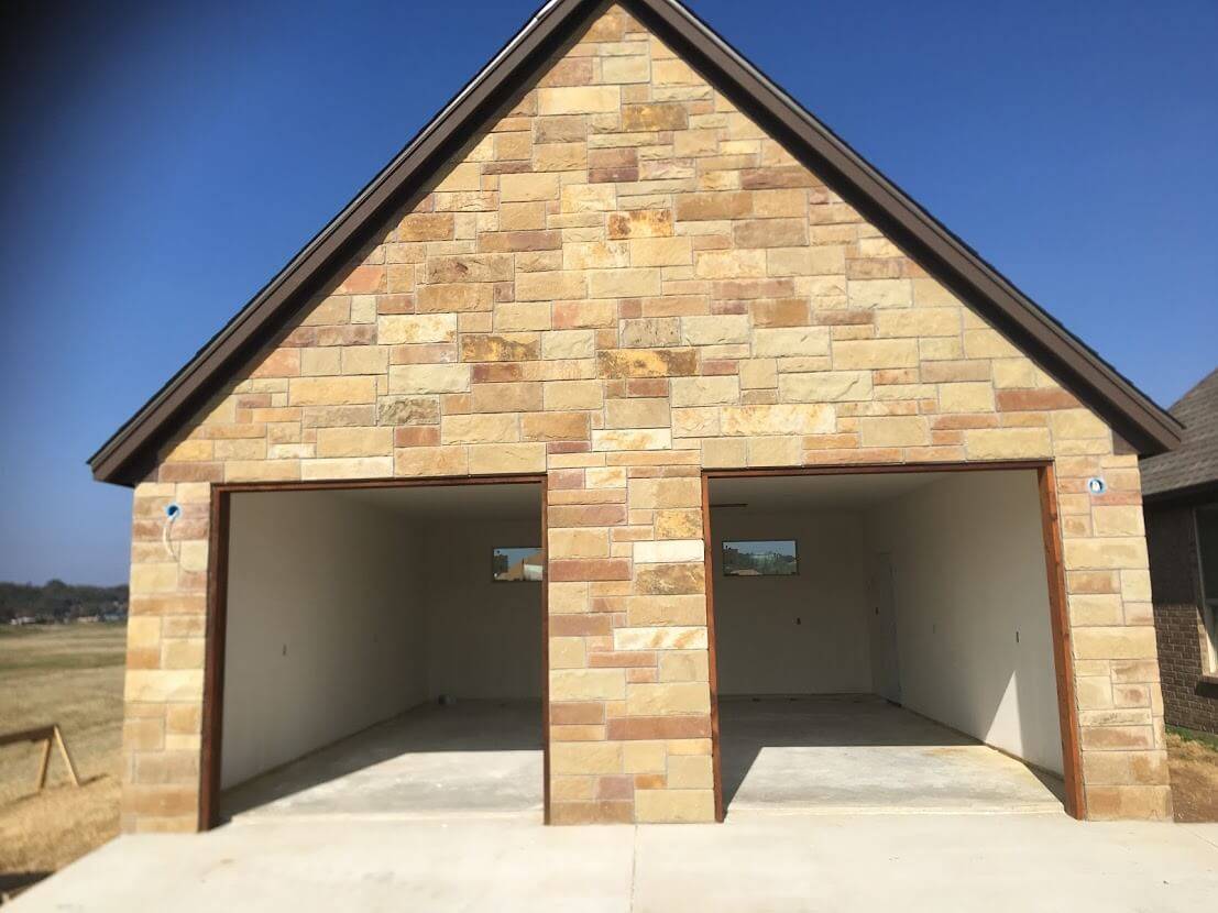 Stone garage with two open bays and unfinished interior walls